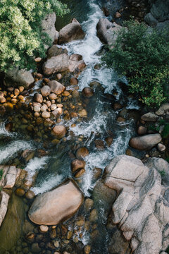 Aerial view of rocky river stream flowing through forest