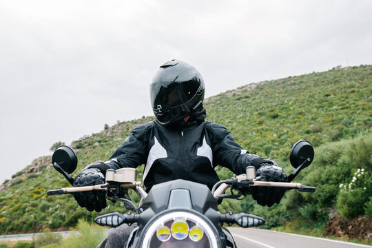 Motorcyclist on open road with helmet and jacket