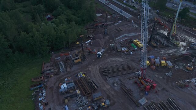 Wide drone panorama of industrial construction site with cranes excavators and concrete structures under development