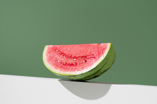 Minimal still life of watermelon slice on green background