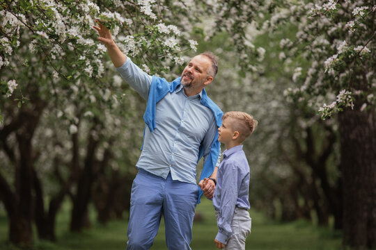 Father and son enjoying spring bloom in orchard together