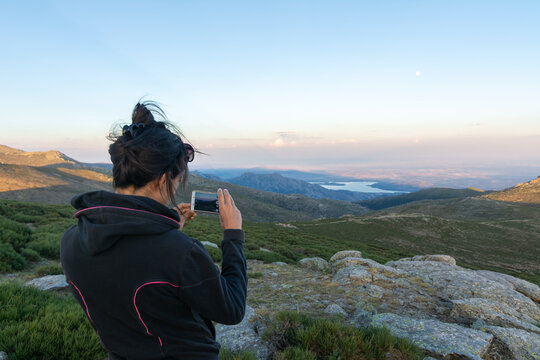Hiker photographing sunset mountain view in Sierra de Guadarrama