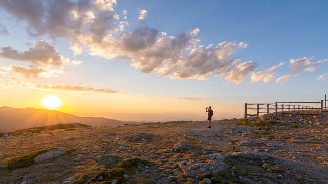 Hiker at sunset overlooking sierra de Guadarrama peak