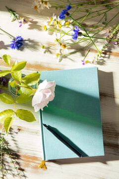 Outdoor journaling still life with notebook, pen and flower