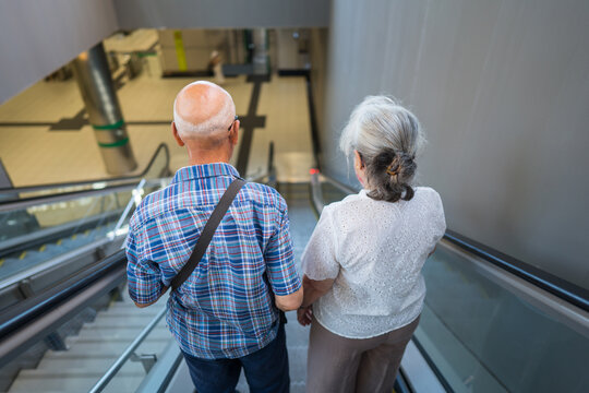 Senior couple on metro escalator embracing urban mobility