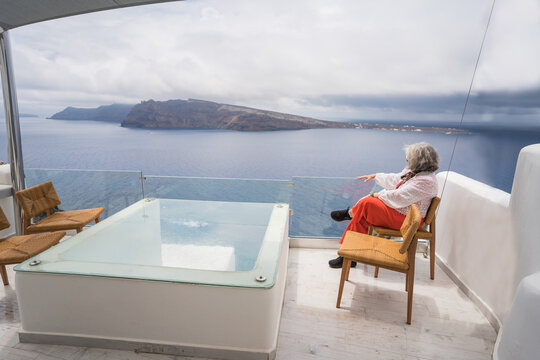 Senior woman relaxing at Santorini luxury hotel terrace