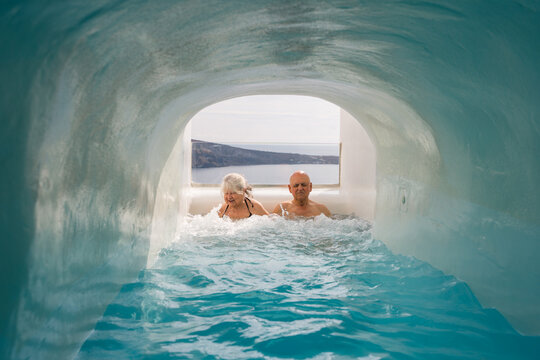 Senior couple relaxing in luxury hotel grotto pool