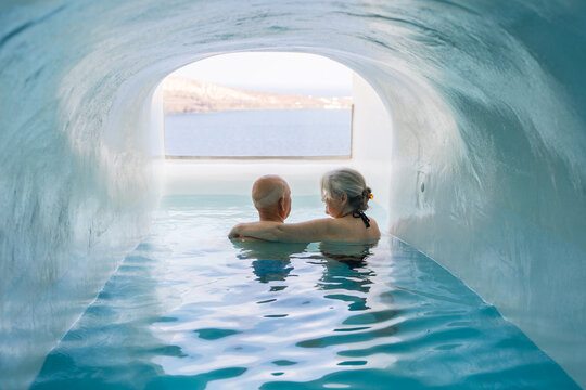 Senior couple relaxing in luxury hotel pool in Santorini