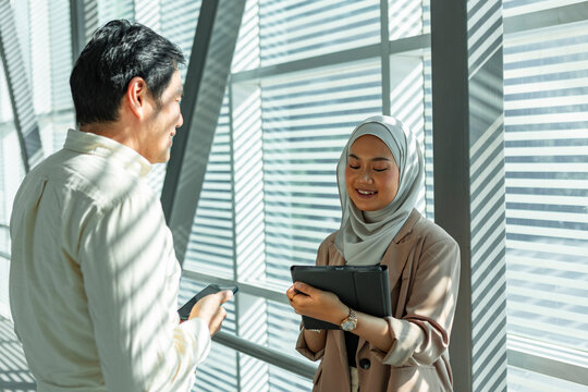 Business colleagues talking in a sunlit modern office