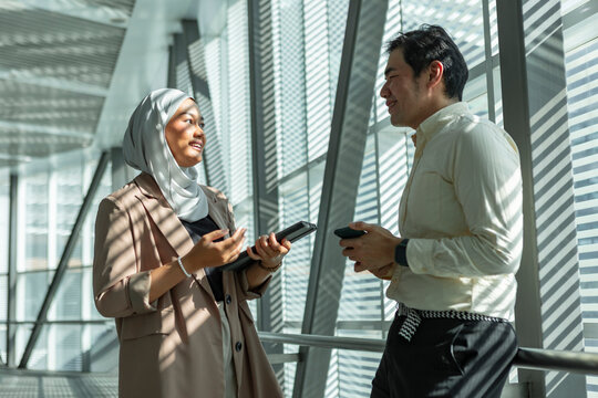 Business colleagues chatting in modern office corridor