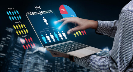 A professional interacts with a laptop displaying HR management information and analytics, showcasing teamwork and data insights amidst a modern urban backdrop. Ledger © InfiniteFlow