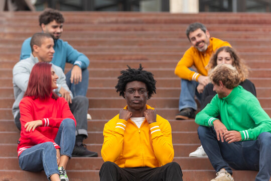 Diverse group wearing colorful sweatshirts on steps