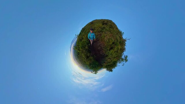 Hiker standing on a tiny planet in front of a volcano