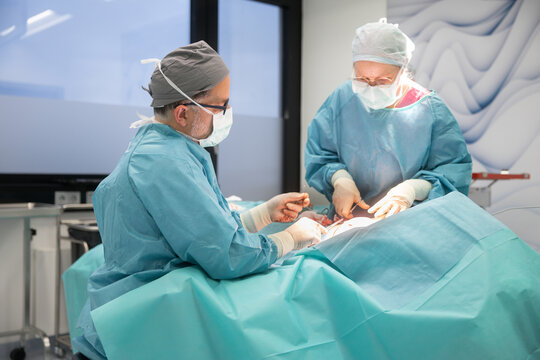 Surgical team performing breast reduction surgery