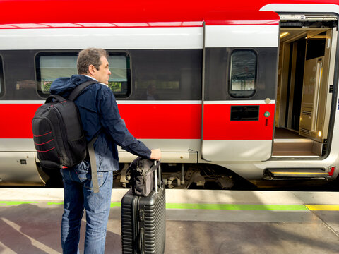 Traveler with luggage waiting beside a train