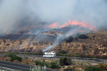 An ambulance races along a highway as a fast approaching wildfire threatens the vicinity of Los Gallardos in Almeria province in southern Spain amid an urgent emergency evacuation and rescue response. © Arafat