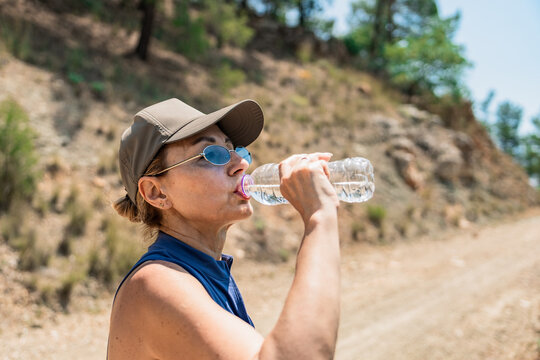 Mature woman hiking in the mountains with water bottle
