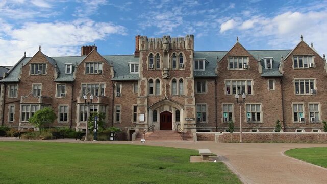 Gothic university building with green roof and lawn.