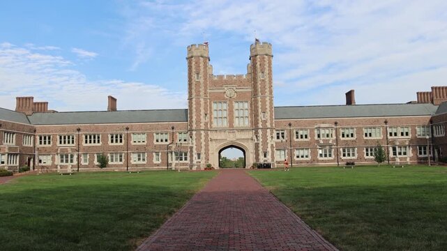 Brick university building with arched gateway and courtyard.
