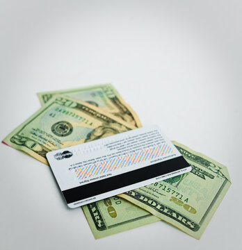 Modern Credit Card Over Crumpled US Currency: Financial Evolution