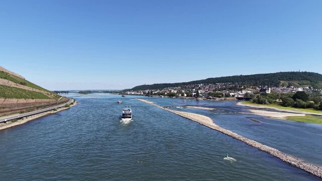 Wide drone aerial view of the Rhine River between Bingen am Rhein and Rudesheim, Germany, featuring river islands, rocky shallows, vineyards and the scenic landscape of the Upper Middle Rhine Valley
