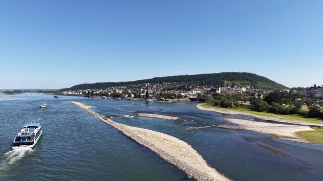 Wide drone aerial view of the Rhine River between Bingen am Rhein and Rudesheim, Germany, featuring river islands, rocky shallows, vineyards and the scenic landscape of the Upper Middle Rhine Valley