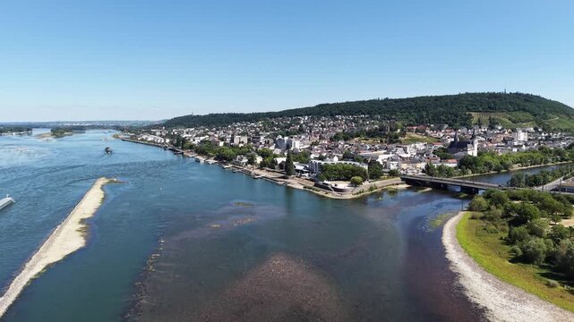 Drone aerial view of Bingen am Rhein at the confluence of the Rhine and Nahe rivers in Germany. Scenic cityscape with historic architecture, waterfront, bridges, green hills and vineyards in the Upper