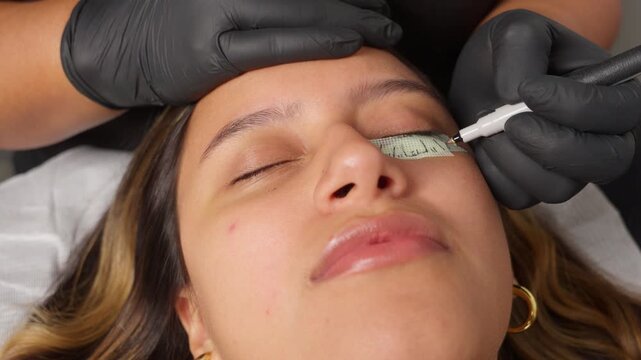 Lash artist mapping eyelash extensions on a young woman
