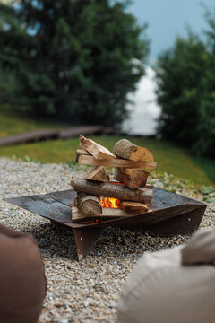 Cozy evening campfire with burning firewood at an eco hotel campsite.