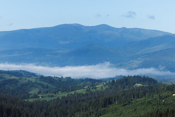 Obraz premium Beautiful foggy valley in Ukrainian Carpathians with rural village houses.