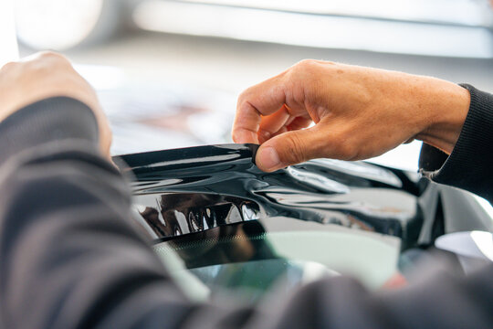A car wrapping specialist applies a polyurethane film to the car. Detailer PPF