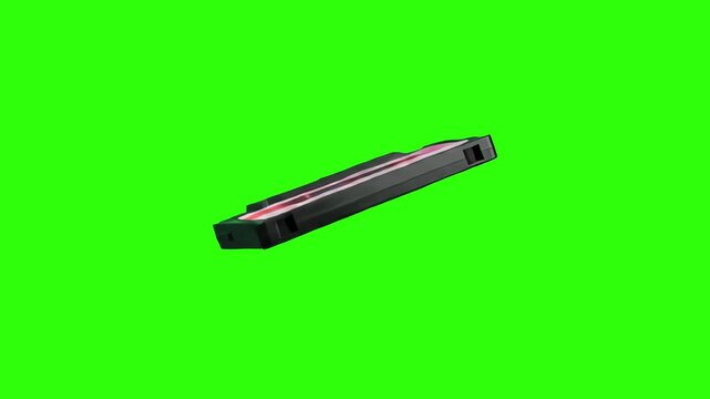 A classic 1990s black VHS tape cassette floating diagonally against a bright green screen background. Excellent for retro media projects, 80s and 90s nostalgia videos, and vintage visual effects compo