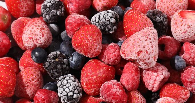 Mix of frozen berries as background, spinning. Top view