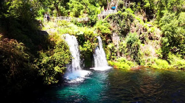 Aerial Horizontal Stationary View of Two Waterfalls Flowing into a Turquoise Crystal Clear Forest Pool, Chile
