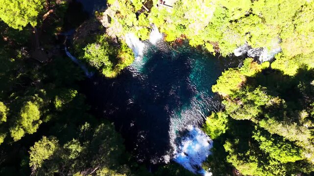Drone Horizontal Zooming In Top Down View of Ojos del Caburgua Blue Forest Pool and Waterfalls, Chile