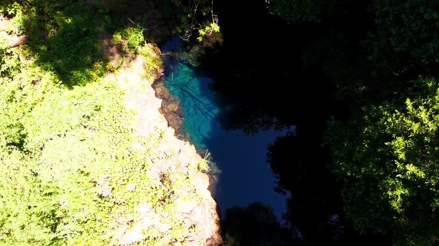 Drone Vertical Zooming Out Top Down View of a Crystal Clear Blue Water Pond Hidden in the Forest, Chile