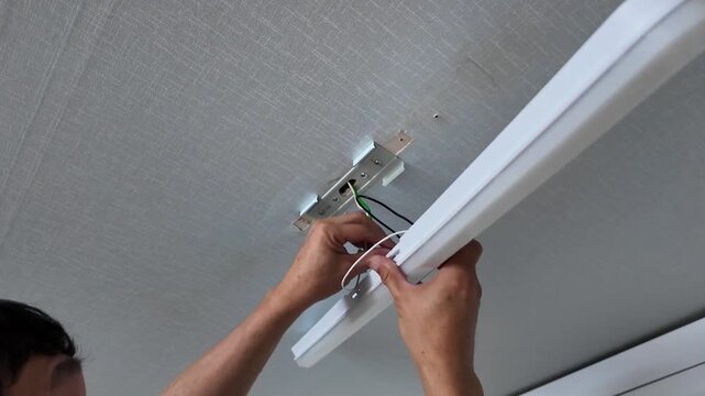 Person changing kitchen ceiling bulb. 