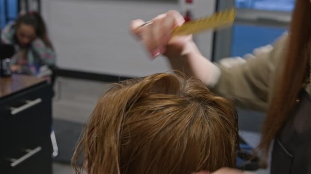 Creative hairstyling session in a cozy salon capturing skillful hands at work over lovely, gleaming locks