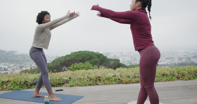 Diverse female friends meeting on wooden deck, warming up on yoga mats, brushing bottle and phone
