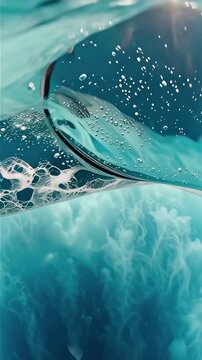 Pristine turquoise ocean wave breaking directly over camera in dynamic POV transitioning underwater with bubbles and sunlight rays, cinematic nature footage