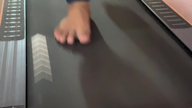 Someone is jogging indoors on a treadmill without wearing athletic shoes. Engaging in this type of activity is extremely dangerous.
