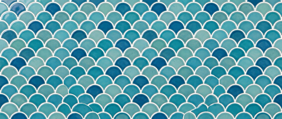 Blue fish scale ceramic mosaic tile texture forming a seamless glossy pattern for coastal bathroom kitchen and pool designs © UmmeFarhatunnesa