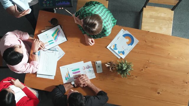 Top down aerial view of smart business man hold tablet and show financial chart at meeting table with financial document. Manager placed tablet at table while investor looking at graph. Convocation.