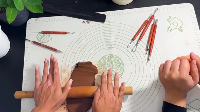 Hands sculpting with brown self-hardening clay close up