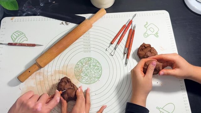 Hands sculpting with brown self-hardening clay close up
