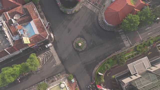 Aerial spiral view captures a road intersection forming a striking urban transportation pattern