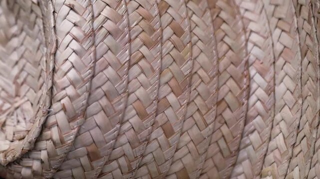 Close-up of stacked woven straw hats showing detailed texture and natural fiber pattern