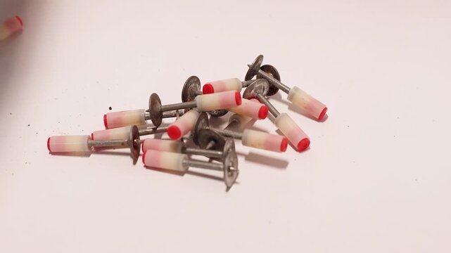 Professional dental laboratory grinding bits and polishing tools scattered on white surface