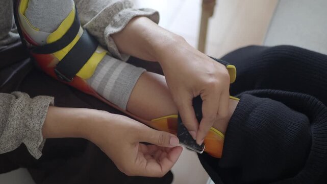 Caregiver Adjusting Orthopedic Leg Brace on Child