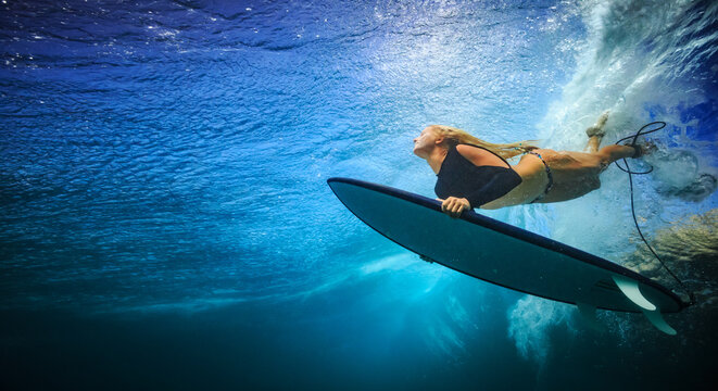 Underwater View of Female Surfer Holding Board and Looking Up